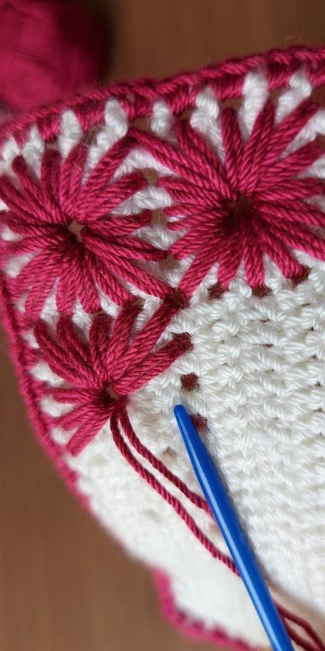 a crocheted doily with a blue ball of yarn next to it