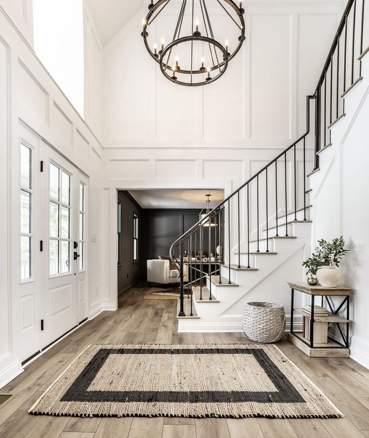 a large foyer with stairs and chandelier in the center, along with an area rug on the floor