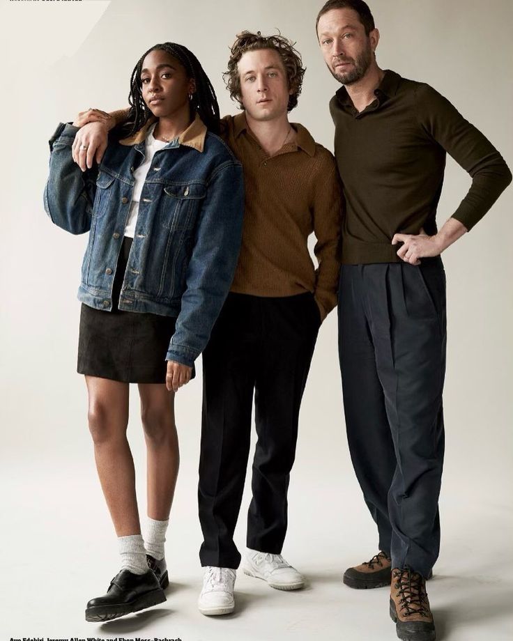 three people standing next to each other in front of a white background