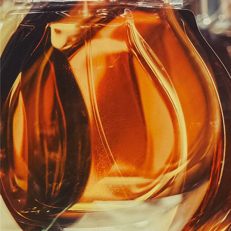 an orange glass vase sitting on top of a table