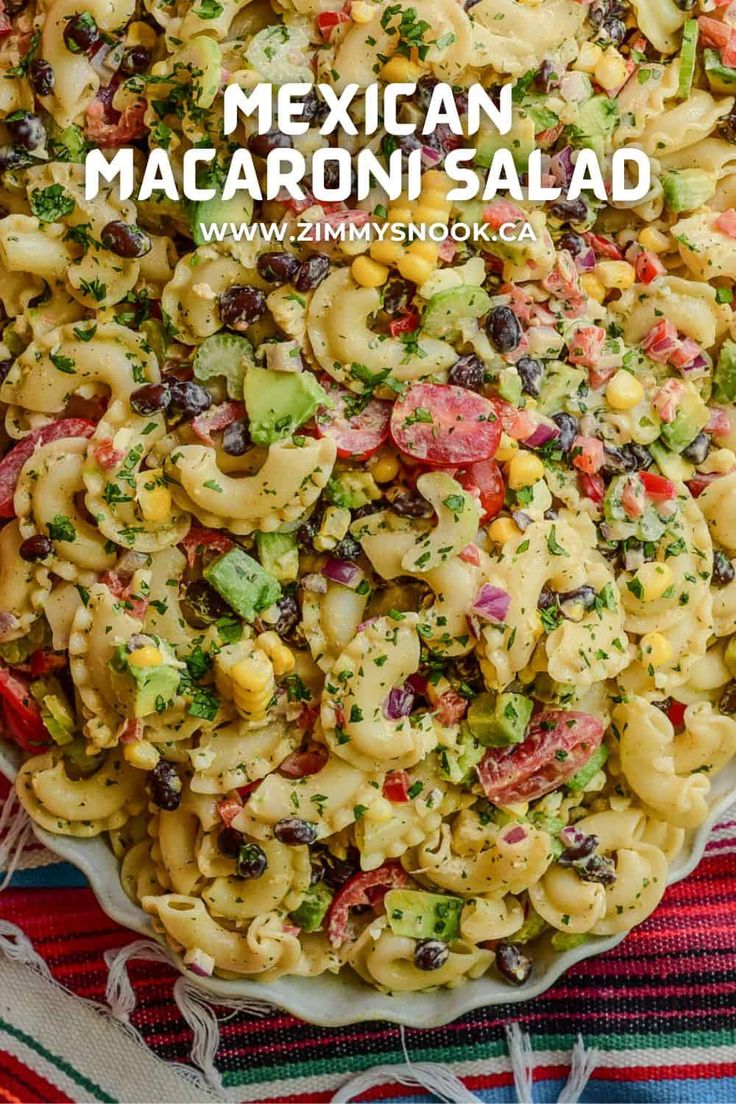 mexican macaroni salad in a white bowl on top of a colorful table cloth