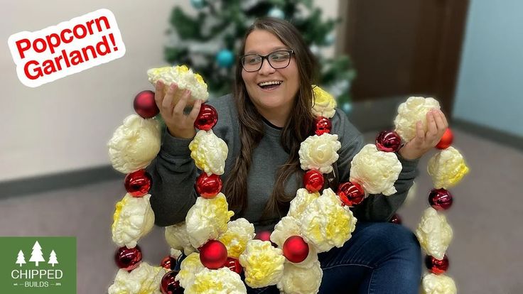 a woman sitting in front of a christmas wreath made out of fake cauliflower