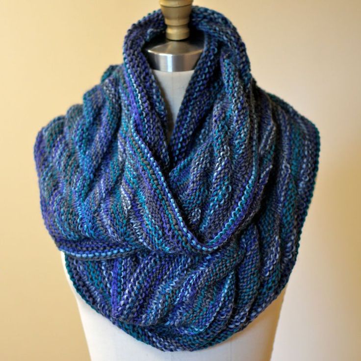 a knitted blue scarf on top of a mannequin headdress,