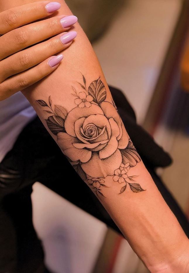 a woman's arm with a rose tattoo on it, and another person holding her hand