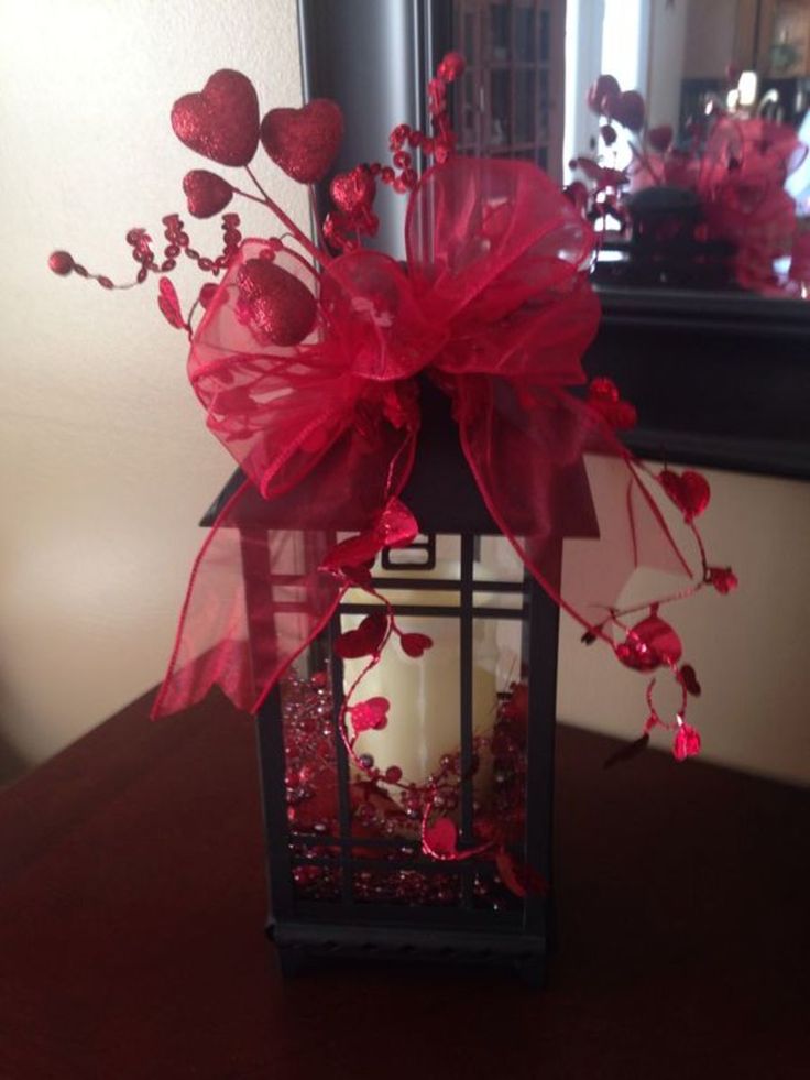 a lantern with red flowers and hearts on it