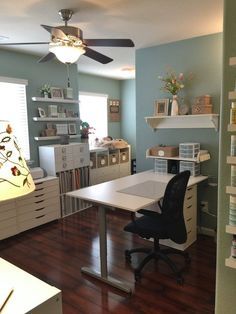 a room with a desk, chair and shelves in it