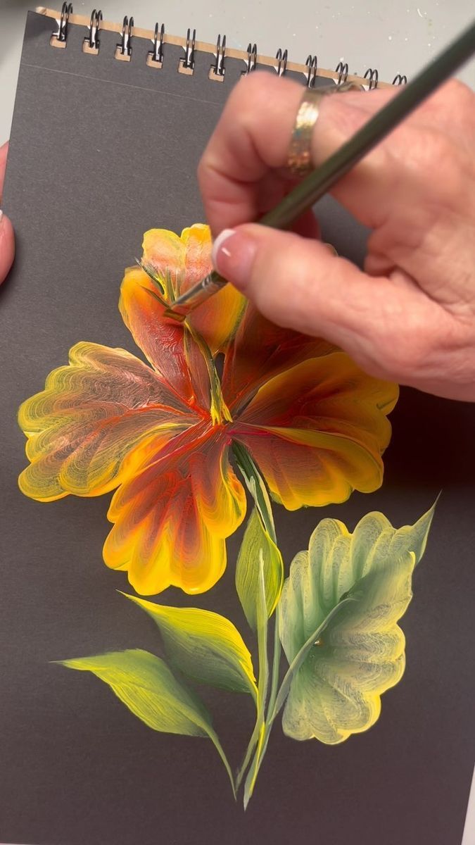 a person is drawing flowers with colored pencils