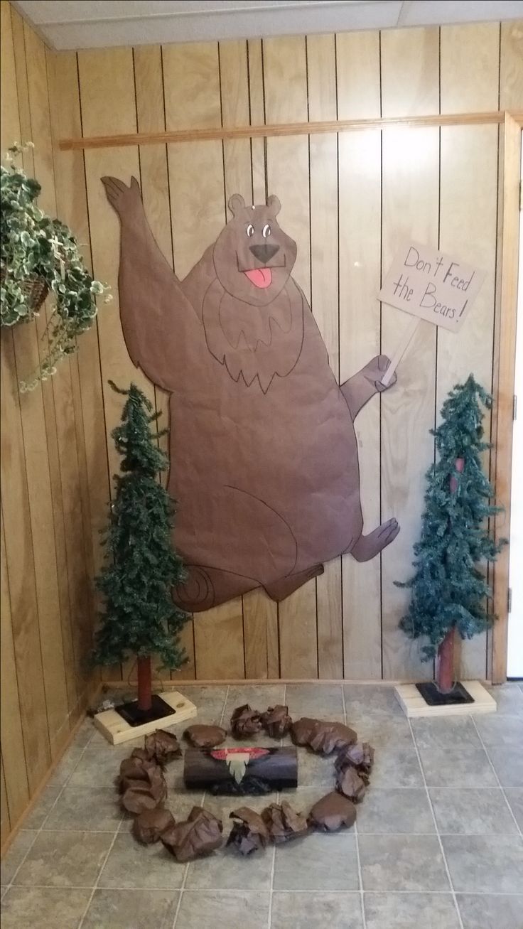 a large paper cut out of a bear in the middle of a room with trees