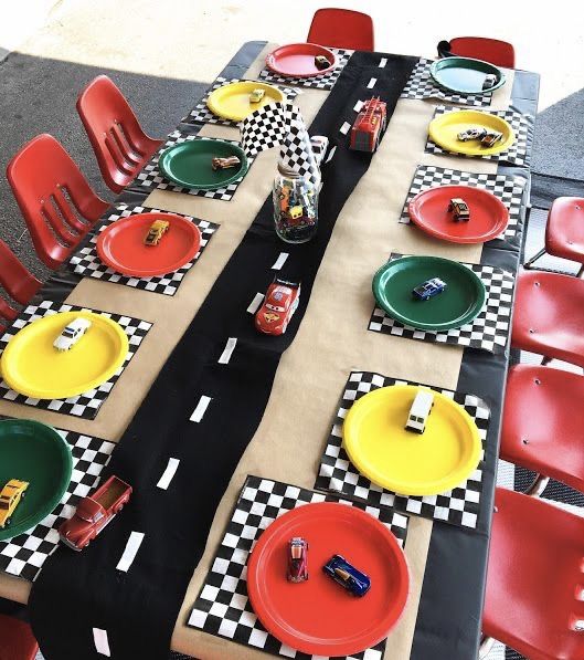 the table is set with race cars plates and napkins for racing themed birthday party