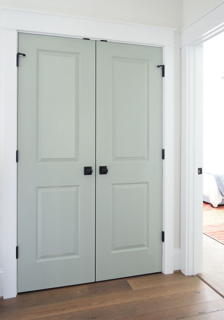 two white doors in a room with hardwood floors and hard wood flooring on the side