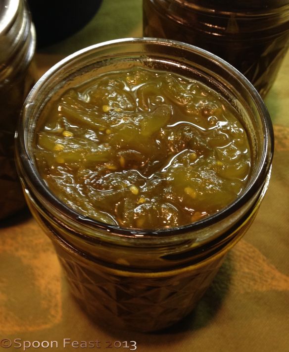 two jars filled with pickles sitting on top of a table