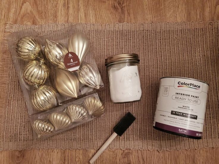 some gold ornaments are sitting on the floor next to a paint can and brush, along with other items