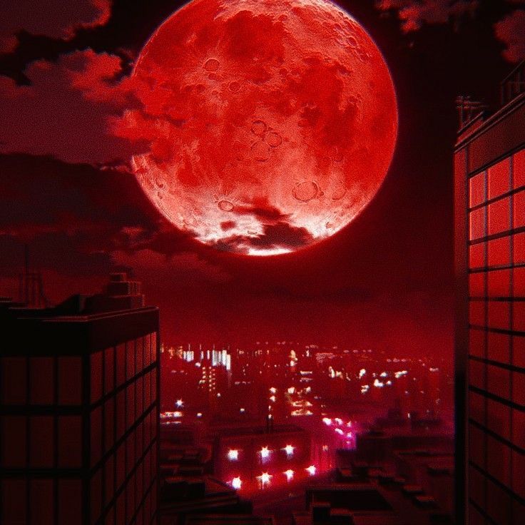 a red moon is seen over a city at night