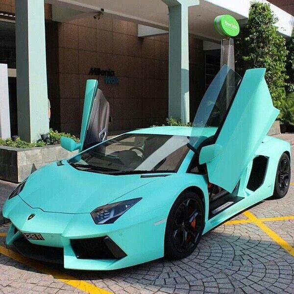 a blue sports car parked in front of a building