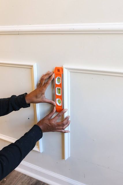 two hands are holding an orange and white door handle