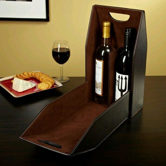 a bottle of wine and two bottles of wine in a wooden holder on a table