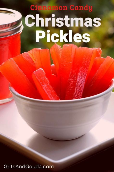 a white bowl filled with christmas pickles sitting on top of a table next to a jar