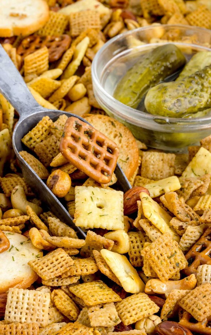 a bowl filled with cheetos and pickles next to a container of pickles