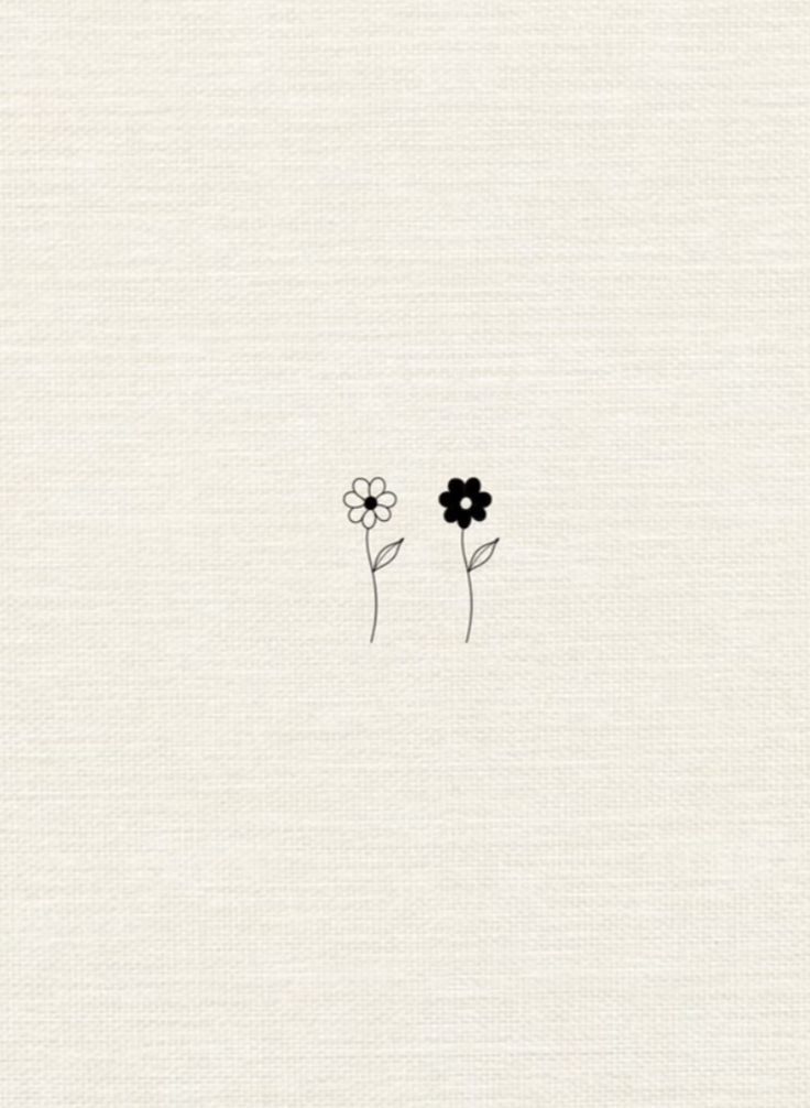 two black flowers sitting on top of a white sheet with the word love written in it