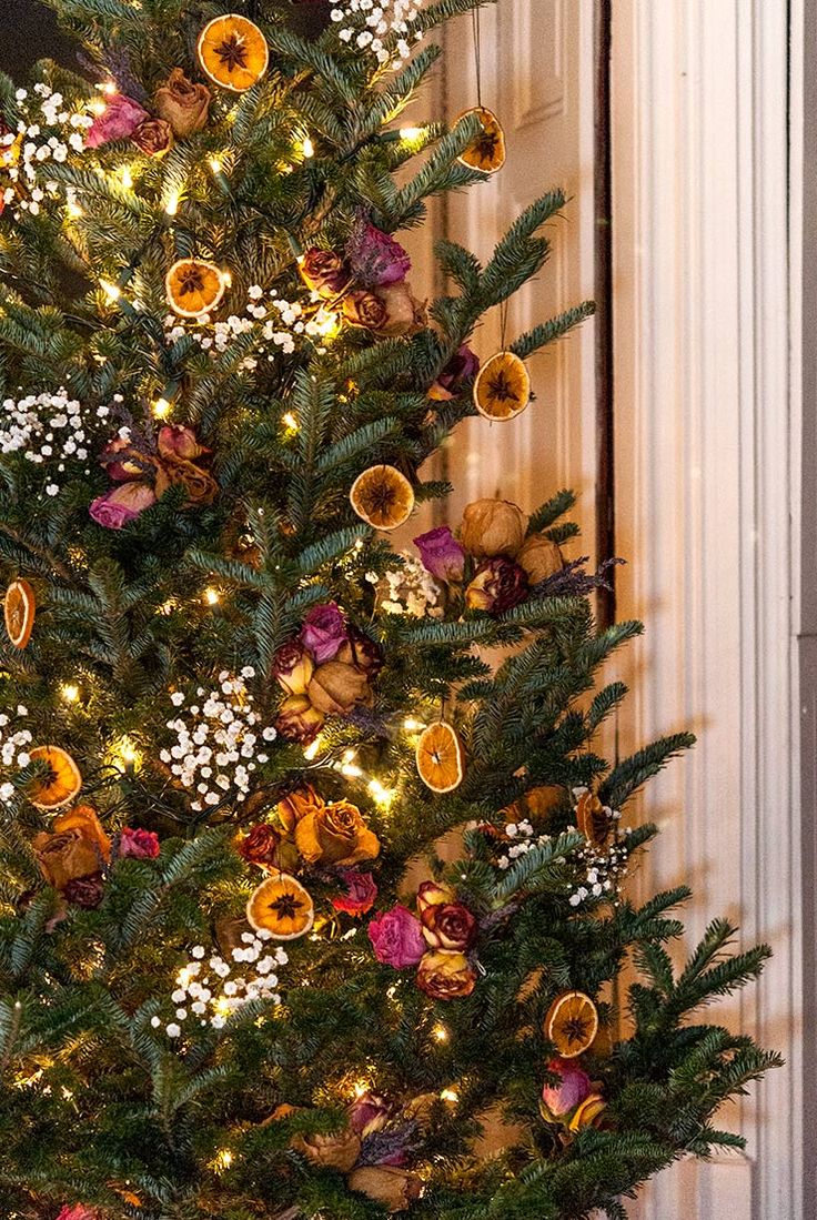 a decorated christmas tree in front of a door with lights and ornaments on the branches