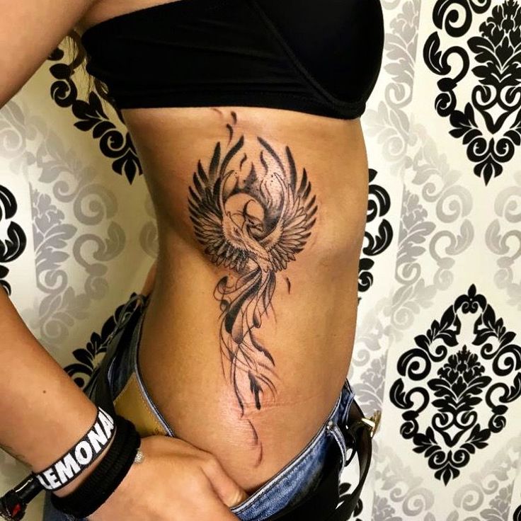 a woman's stomach with a tattoo on her belly and an eagle in the center