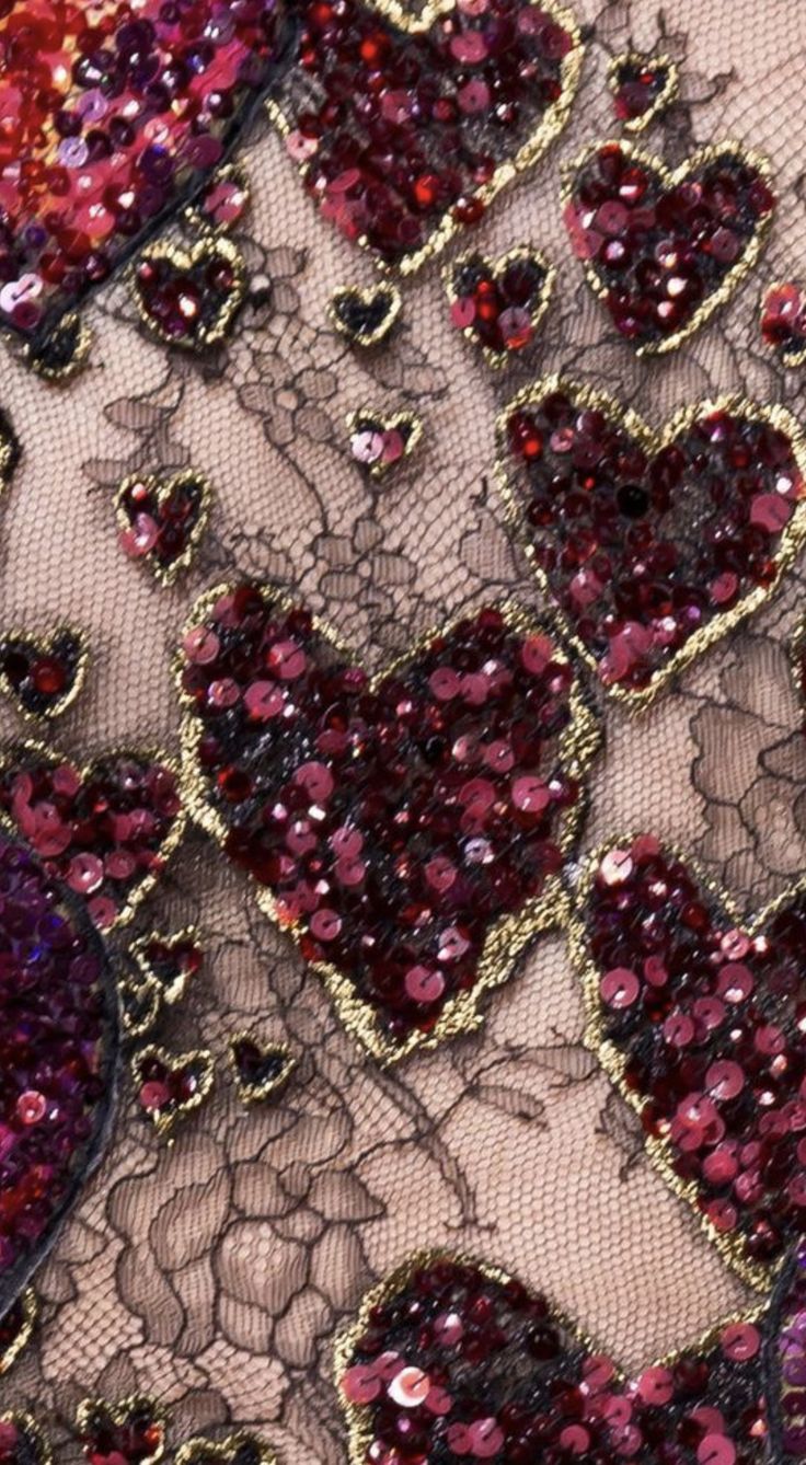 red and gold sequins on black lace with hearts in the center, closeup