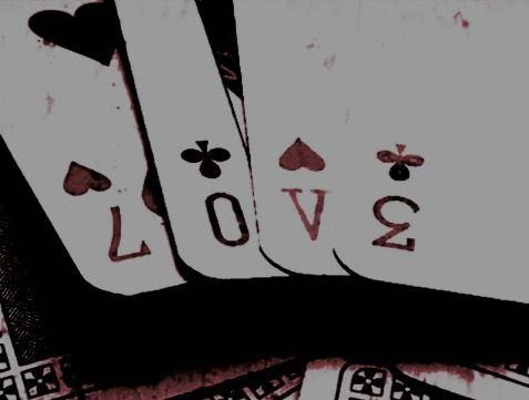 four playing cards with the word love written on them in black and white ink, sitting next to each other