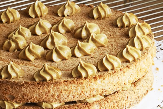 a cake with frosting on top sitting on a cooling rack