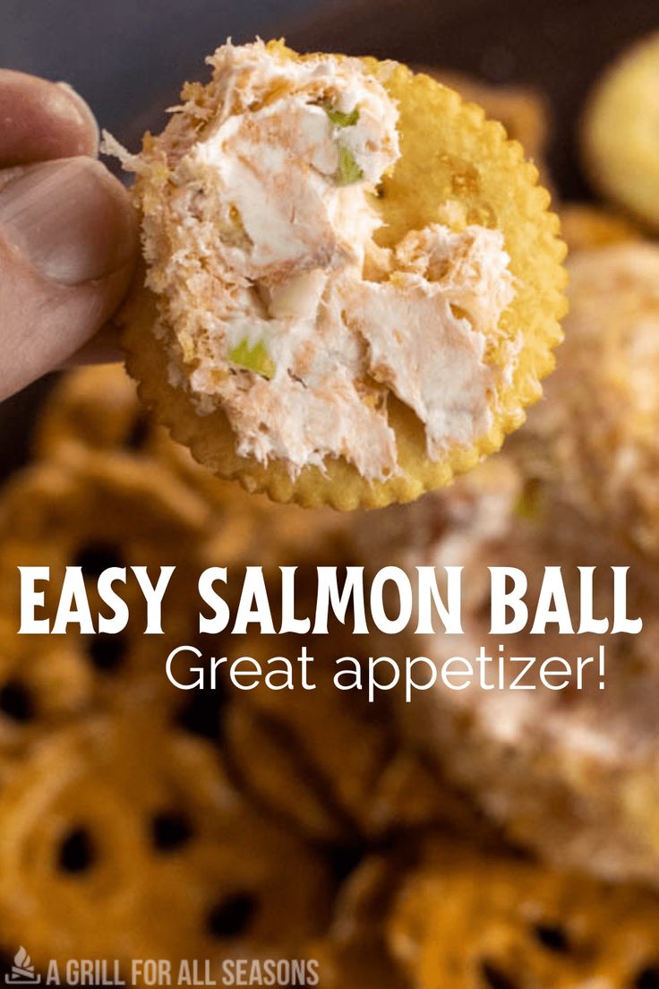 a hand holding up a cracker filled with chicken salad and text overlay that reads easy salmon ball great appetizer