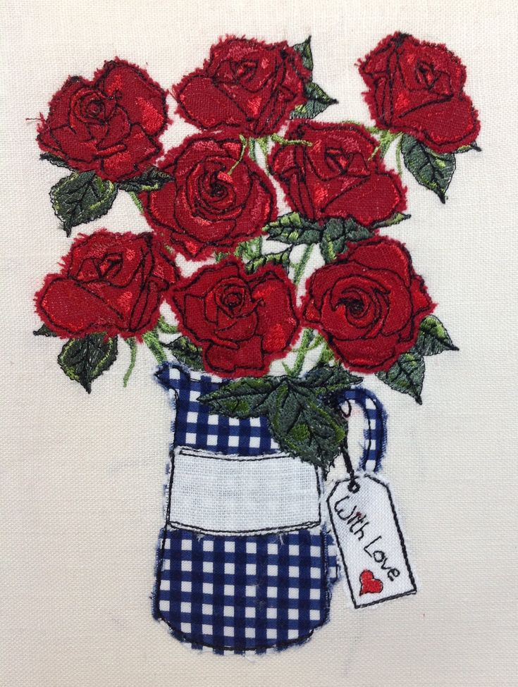 a bouquet of red roses in a blue and white checkered vase with a tag