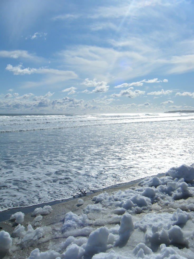 the ocean is covered in snow on a sunny day