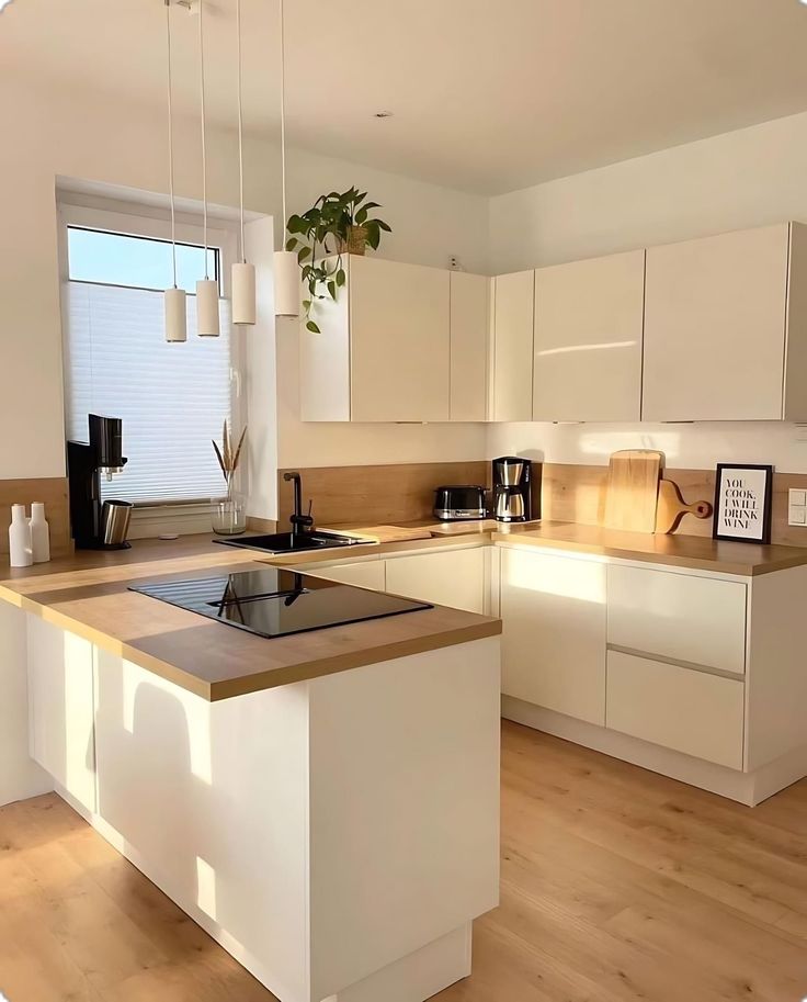 a kitchen with white cabinets and an island in the middle is seen from across the room