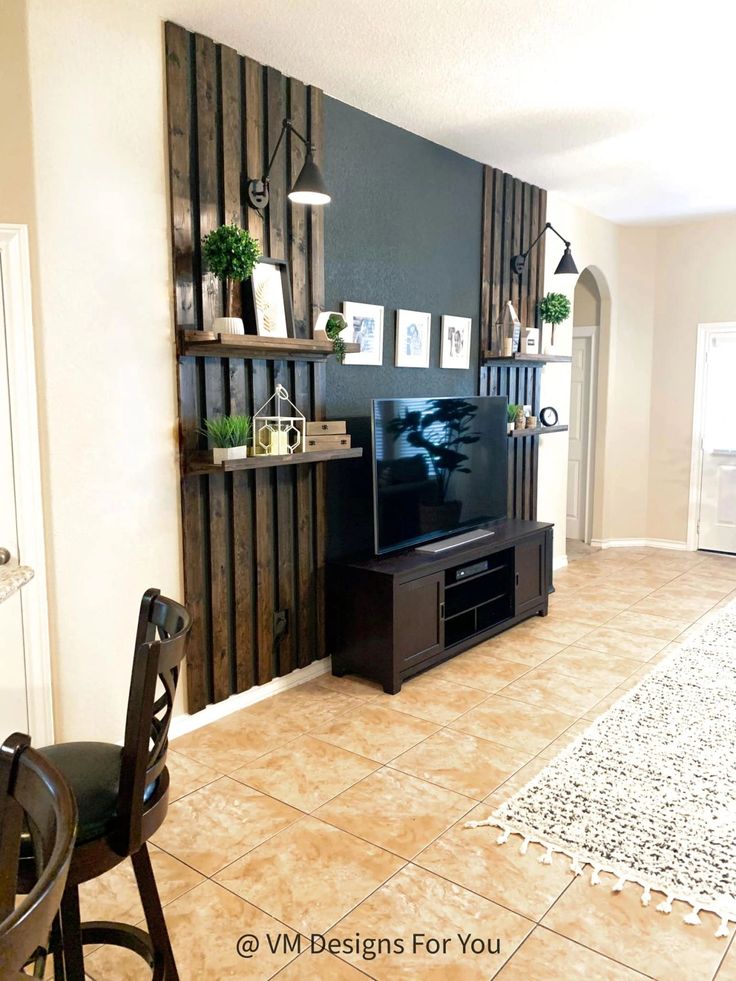 a living room filled with furniture and a flat screen tv on top of a wooden shelf