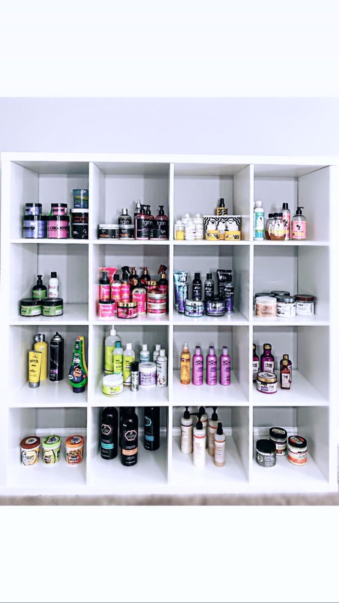 a white shelf filled with lots of different types of hair products