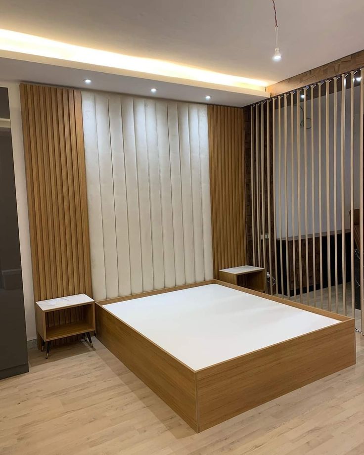 an empty room with wooden slats on the walls and a bed in the middle