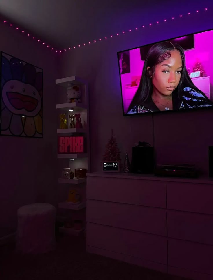 a television that is on in the corner of a room with purple lights around it