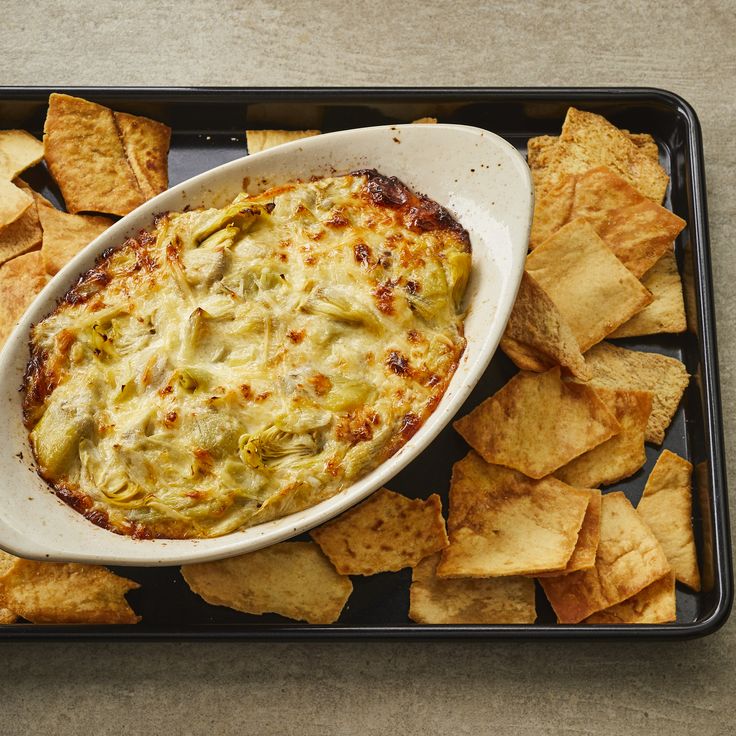 a bowl of dip surrounded by tortilla chips