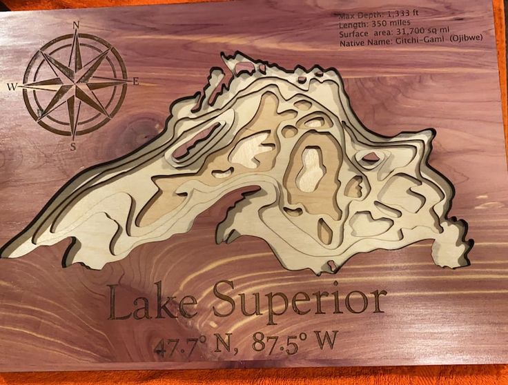 a wooden plaque with the name and map of lake superior