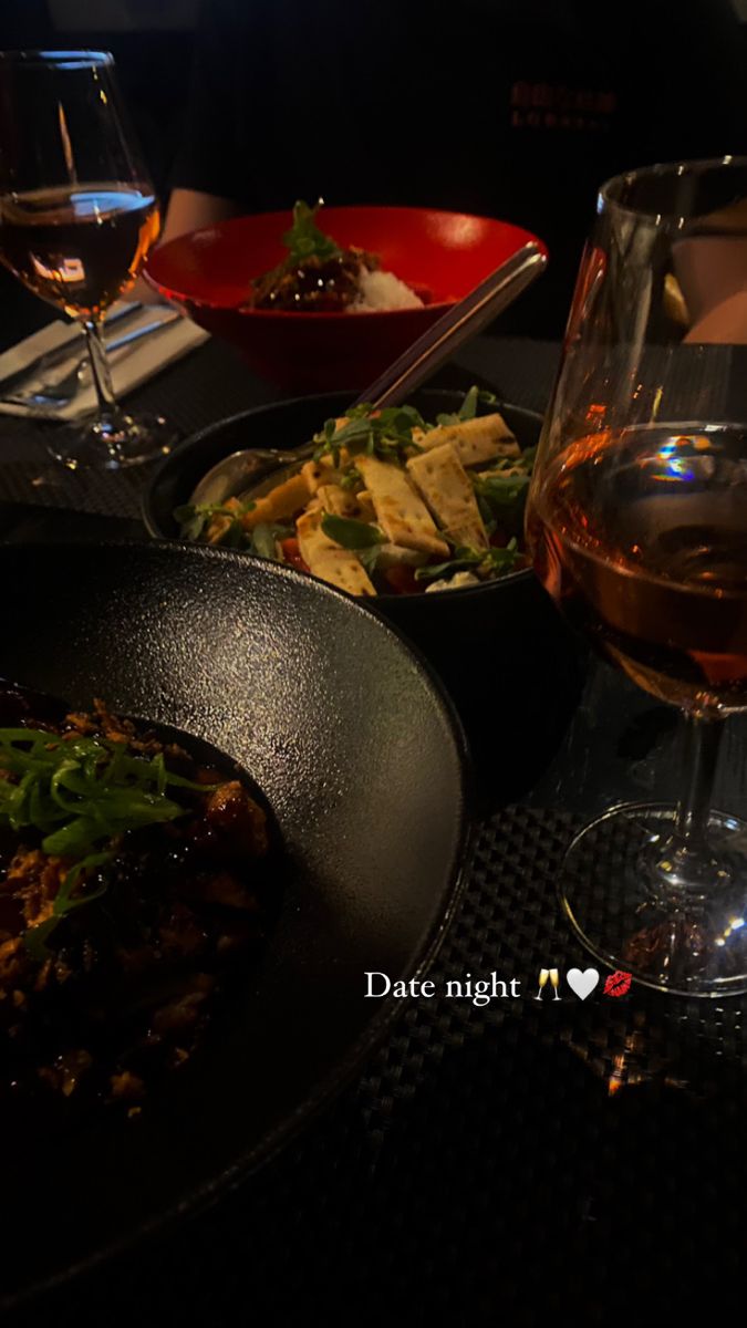 a table topped with plates of food and glasses of wine