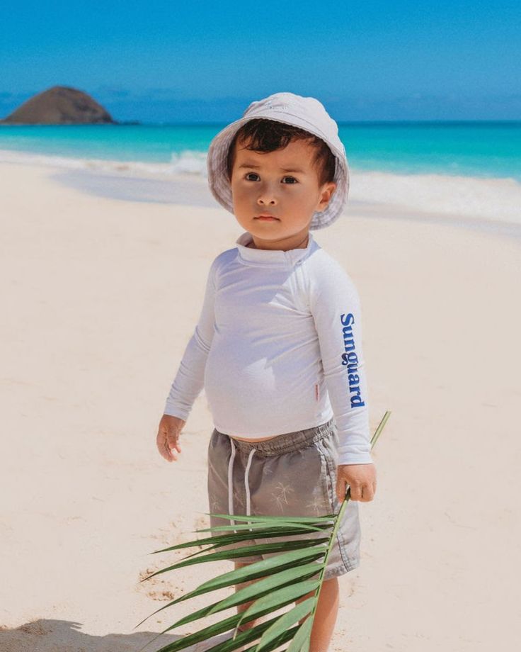 Get ready for a day at the beach with Sunguard’s reversible kids bucket hat. Our toddler bucket hat is constructed with a velcro chin strap and will keep your little one’s skin protected from harsh rays. California cool inspired designs available for both boys and girls in baby, toddler and youth sizing. *Size 6-12month and 1-2year is constructed with a Velcro chin strap to help keep hat on. No chin strap on size 3-5+year Grey 'Pray for Surf' reversible with Grey Palm Trees Khaki Green 'Stoked' Playful Adjustable Bucket Hat With Upf 50+, Playful Upf 50+ Bucket Hat For Playtime, Sun-shaped Bucket Hat For Beach Season Sunbathing, Baby Boy Bucket Hat, Sun Bucket Hat With Uv Protection, One Size, Toddler Bucket Hat, Pray For Surf, Kids Bucket Hat, Baby Ready