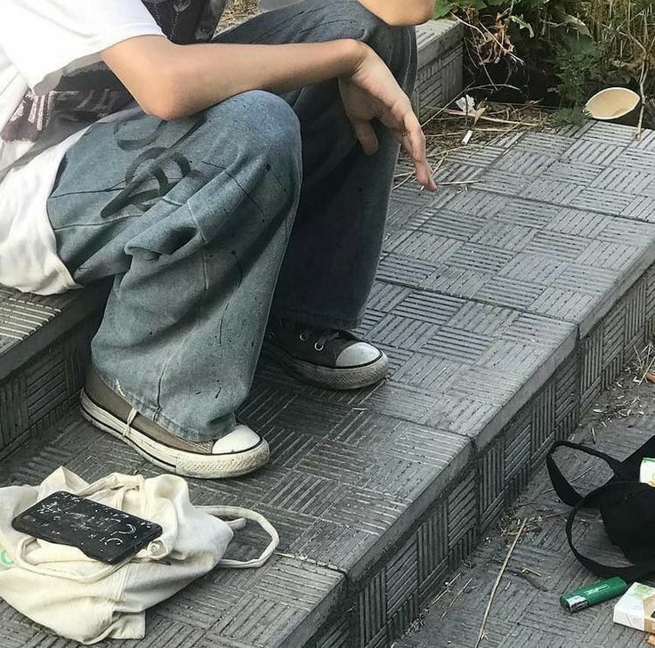 a man sitting on the steps pointing at his cat next to him and other items