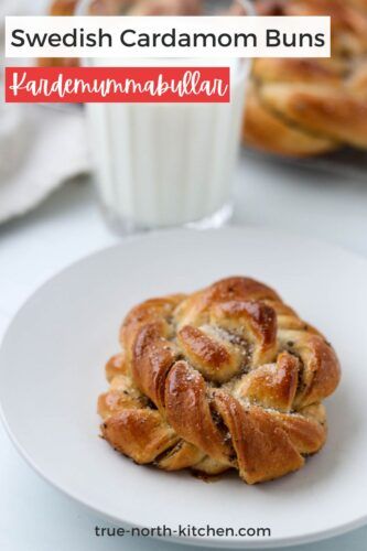 a white plate topped with cinnamon buns next to a glass of milk