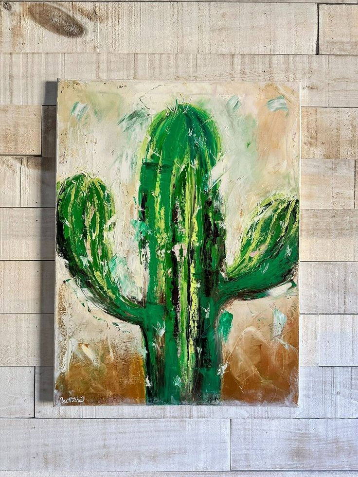 a painting of a green cactus on a white brick wall