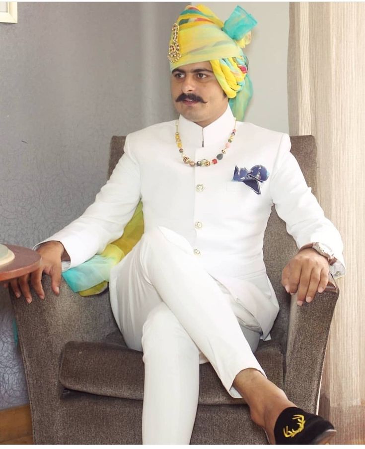 a man sitting in a chair wearing a turban