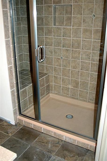 a walk in shower sitting inside of a bathroom