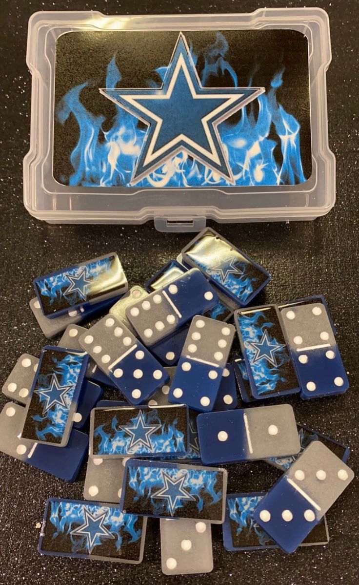 blue and white dominos in a plastic case with a star on the top, surrounded by fire