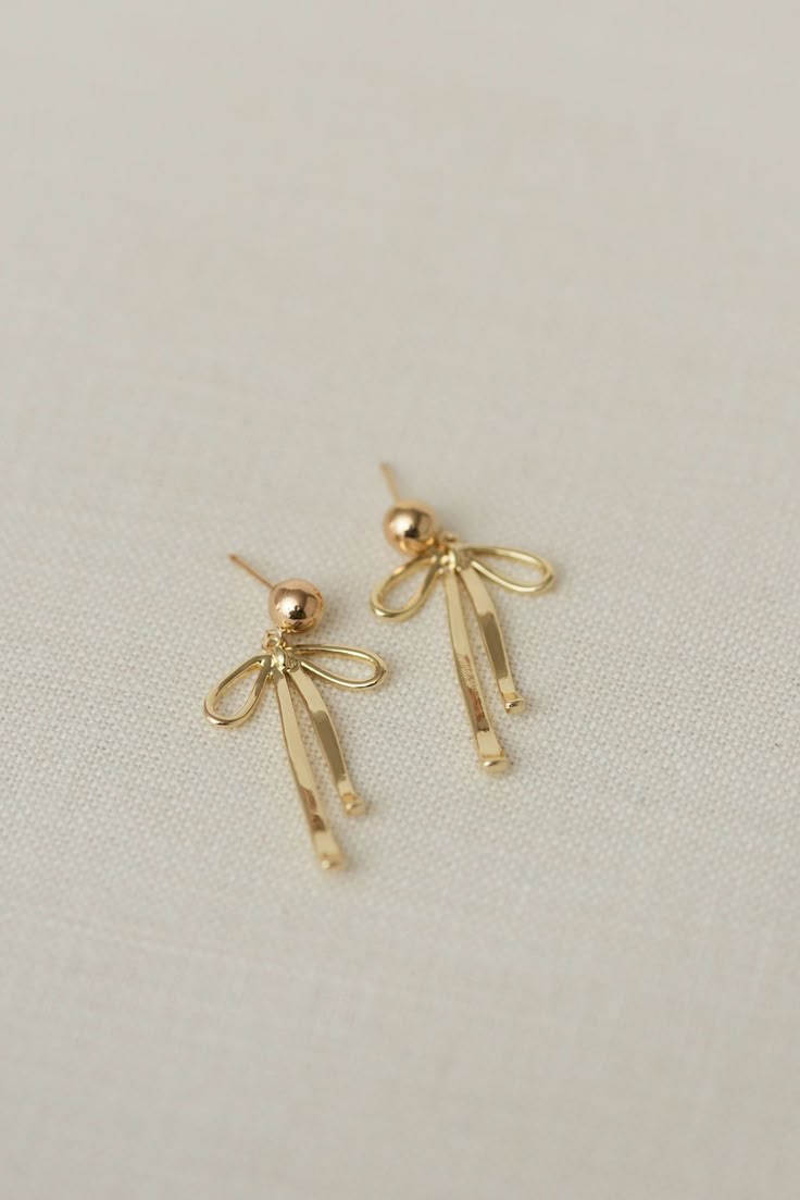 Rumor has is that 2024 is the year of BOWS! These super cute, dangly bow earrings will be the HIT of any party. Includes two gold or silver-plated dangly bow charms 6mm 14k gold-filled or sterling silver, hypoallergenic ball studs Choose from either solid or sparkly Delicate Earrings Gold, It Girl Earrings, Bow Gold Earrings, Dangly Earrings Gold, Dainty Jewelry Earrings, Gold Dangly Earrings, Bow Earrings Gold, Gold Bow Earrings, Quince Earrings