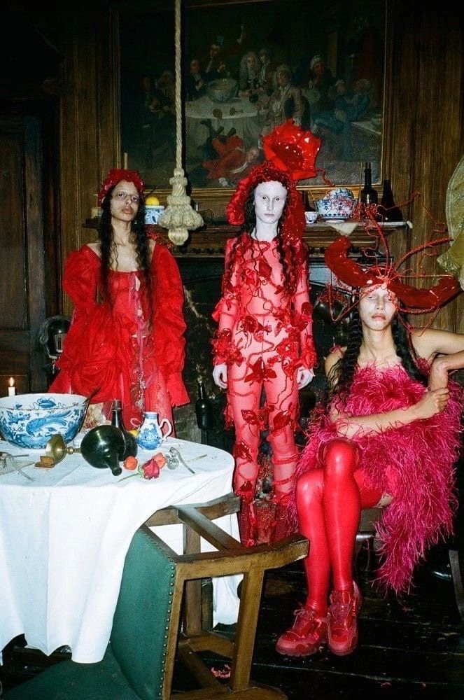 three women dressed in red sitting at a table