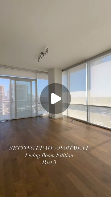 an empty living room with wooden floors and large windows