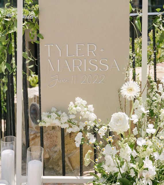 a couple of white flowers sitting in front of a sign